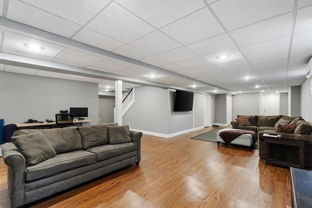 living room with a paneled ceiling and wood-type flooring