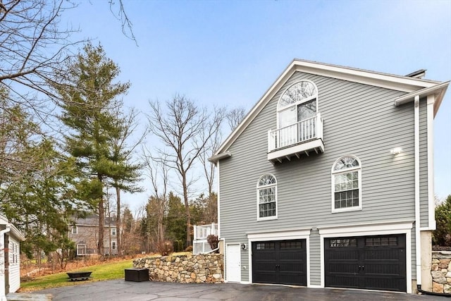 view of home's exterior with a balcony and a garage