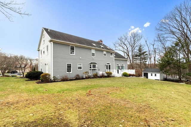 back of property with a lawn and a storage shed