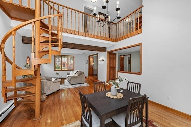 35 Crest Rd, Lynnfield, MA 01940 - dining space with stairs, baseboard heating, wood finished floors, and a towering ceiling