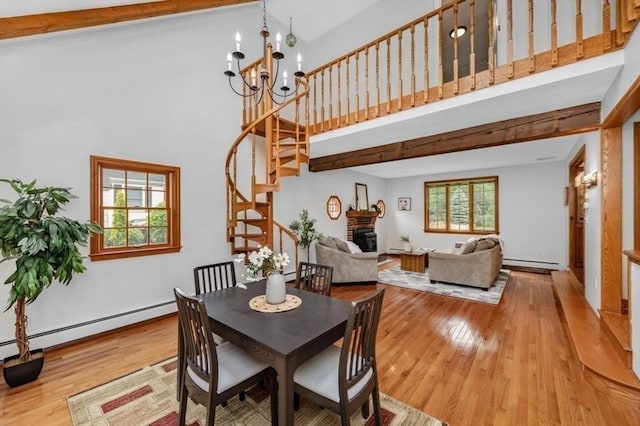 35 Crest Rd, Lynnfield, MA 01940 - dining space featuring baseboard heating, a towering ceiling, a baseboard heating unit, stairway, and wood finished floors