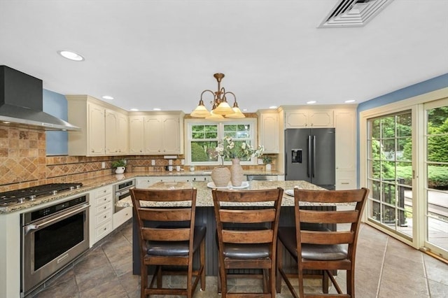 35 Crest Rd, Lynnfield, MA 01940 - kitchen with stainless steel appliances, wall chimney exhaust hood, cream cabinetry, plenty of natural light, and recessed lighting