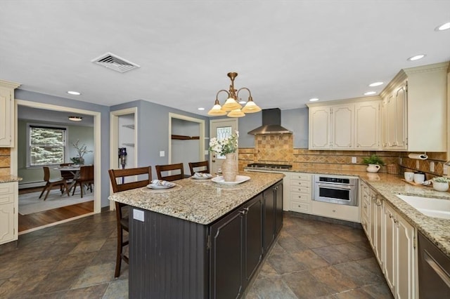 35 Crest Rd, Lynnfield, MA 01940 - kitchen with appliances with stainless steel finishes, wall chimney exhaust hood, cream cabinets, a kitchen bar, and recessed lighting
