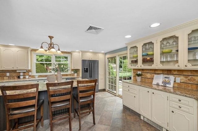 35 Crest Rd, Lynnfield, MA 01940 - kitchen with stainless steel fridge, decorative backsplash, recessed lighting, glass insert cabinets, and cream cabinets