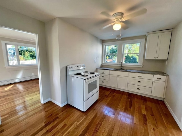 kitchen with white cabinets, dark hardwood / wood-style flooring, white electric stove, and a wealth of natural light