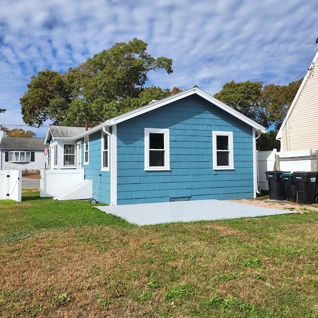 back of property with a lawn and a patio area