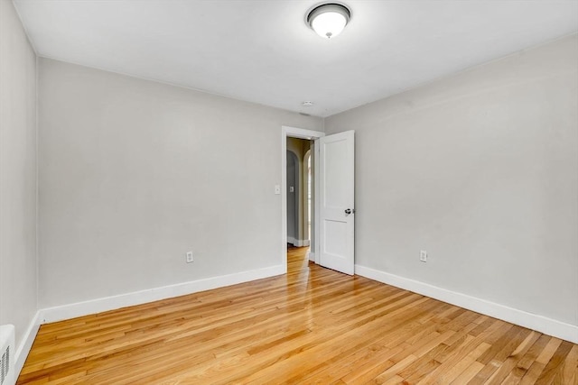 unfurnished room featuring light wood-style floors, visible vents, and baseboards