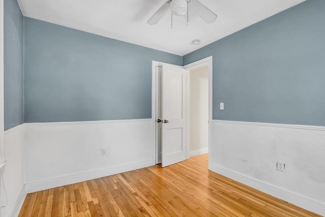 unfurnished room featuring ceiling fan, baseboards, and hardwood / wood-style floors