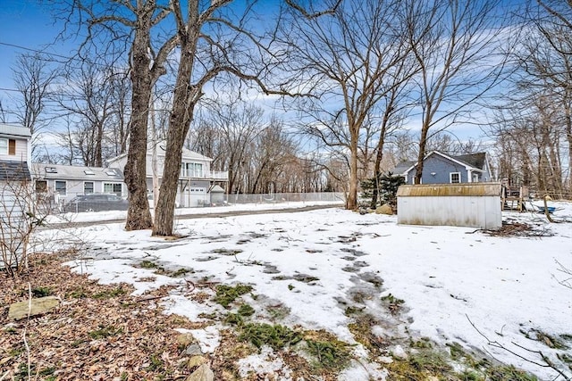 yard covered in snow featuring fence