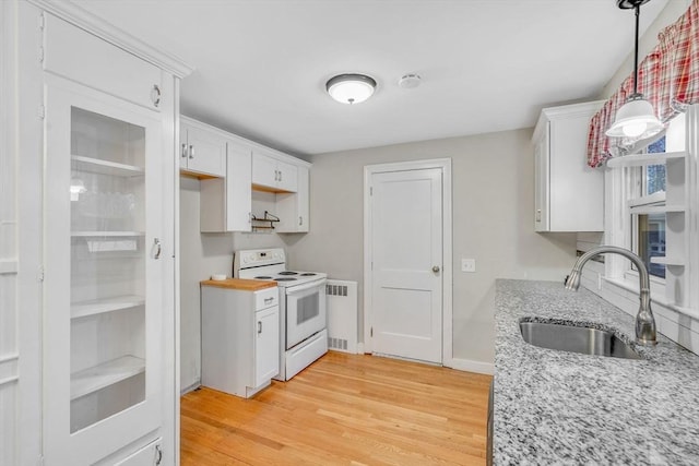 kitchen featuring white cabinets, light wood-style flooring, light stone counters, white electric range, and a sink