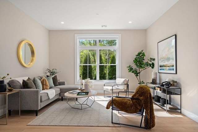 living area with wood finished floors, baseboards, and recessed lighting