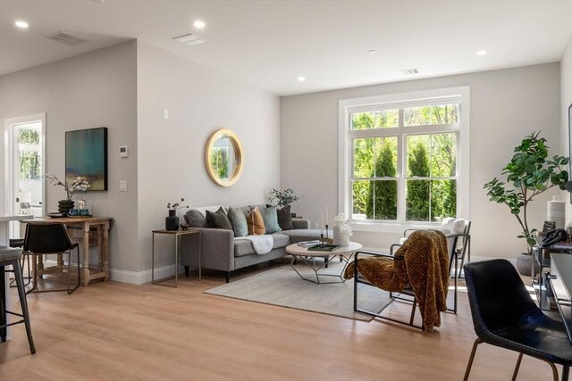 living room with light wood-style floors, recessed lighting, and baseboards