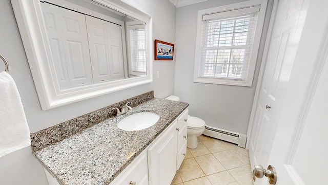 bathroom featuring tile patterned floors, baseboard heating, vanity, and toilet