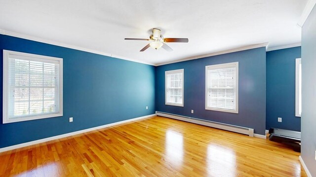 spare room with baseboard heating, ceiling fan, crown molding, and wood finished floors