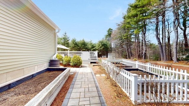 view of yard featuring fence, a garden, and a deck