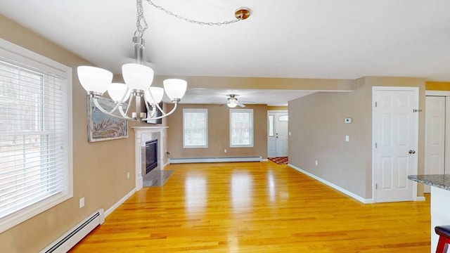unfurnished living room featuring baseboard heating, a baseboard radiator, and light wood finished floors