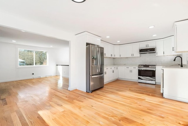 11 Adams St, Foxboro, MA 02035 - kitchen with appliances with stainless steel finishes, a sink, light countertops, extractor fan, and light wood-type flooring