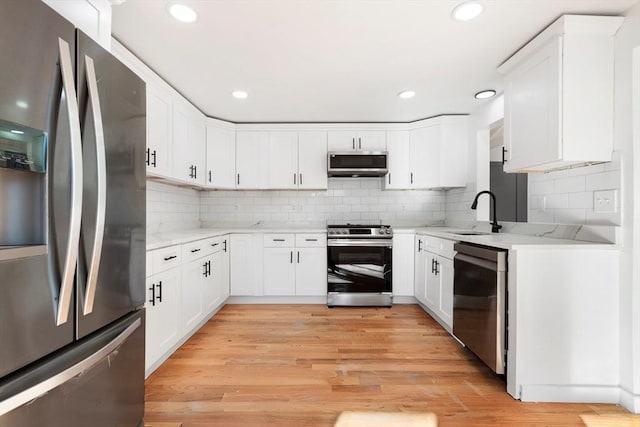 11 Adams St, Foxboro, MA 02035 - kitchen featuring white cabinets, stainless steel appliances, a sink, and tasteful backsplash