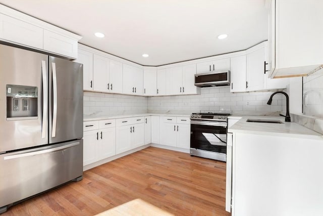 11 Adams St, Foxboro, MA 02035 - kitchen featuring light wood-style floors, a sink, white cabinetry, and stainless steel appliances