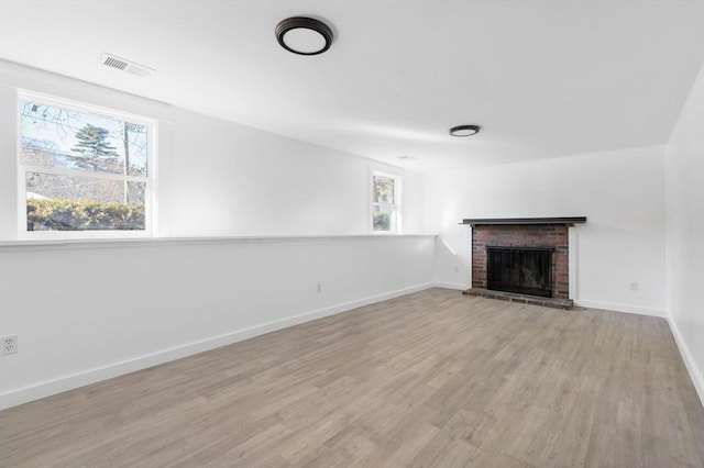 11 Adams St, Foxboro, MA 02035 - unfurnished living room featuring a brick fireplace, visible vents, a wealth of natural light, and light wood finished floors