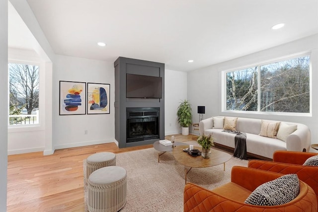 11 Adams St, Foxboro, MA 02035 - living room featuring a large fireplace, baseboards, plenty of natural light, and light wood-style flooring