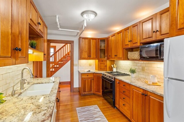 301 Old Billerica Rd, Bedford, MA 01730 - kitchen with freestanding refrigerator, gas stove, a sink, black microwave, and decorative backsplash