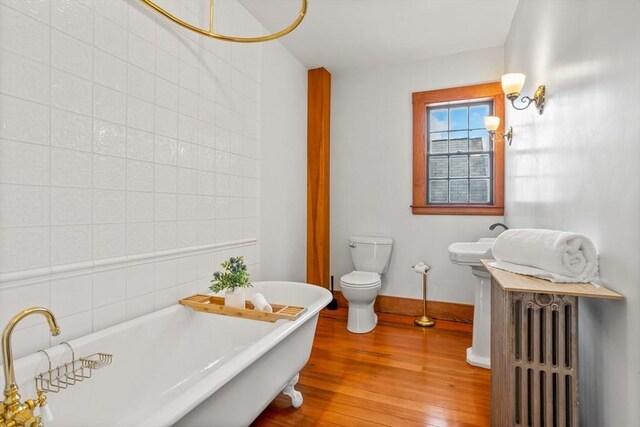 301 Old Billerica Rd, Bedford, MA 01730 - full bath with wood finished floors, toilet, a freestanding tub, baseboards, and a sink