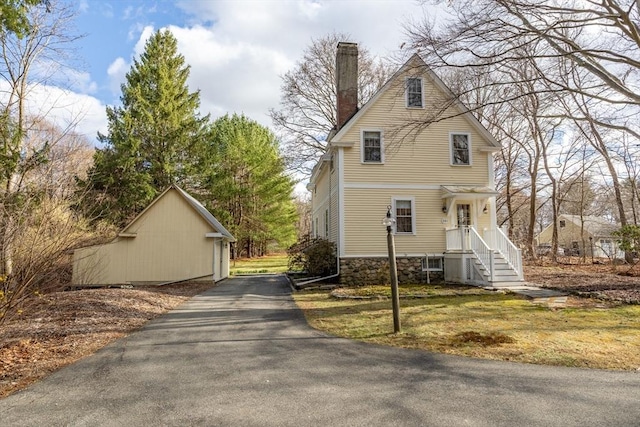 301 Old Billerica Rd, Bedford, MA 01730 - view of front facade with driveway, a chimney, and stone siding