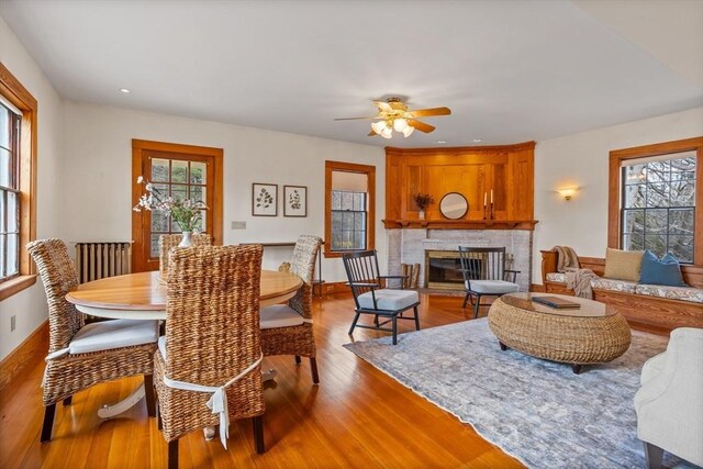 301 Old Billerica Rd, Bedford, MA 01730 - dining area with wood finished floors, a glass covered fireplace, a ceiling fan, recessed lighting, and baseboards