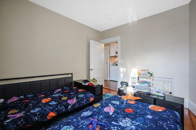 bedroom featuring hardwood / wood-style floors and washer / dryer