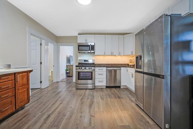 kitchen featuring white cabinetry, appliances with stainless steel finishes, and light wood-type flooring