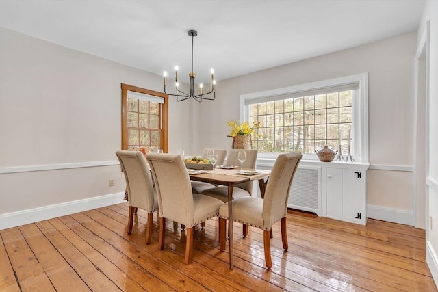 dining room featuring a wealth of natural light, light wood-type flooring, and baseboards