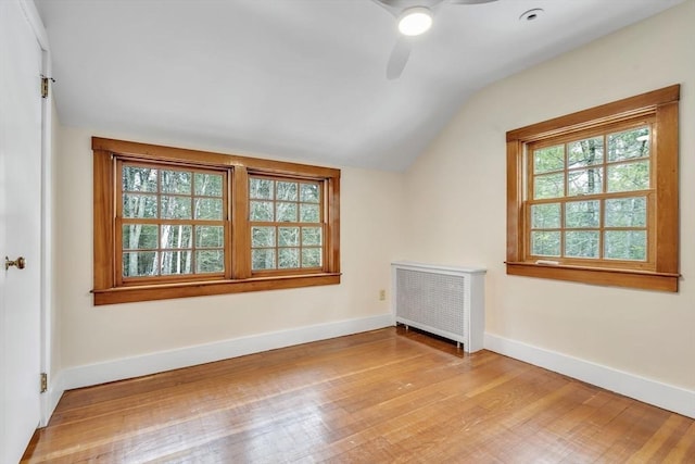 bonus room with vaulted ceiling, light wood finished floors, radiator heating unit, and baseboards