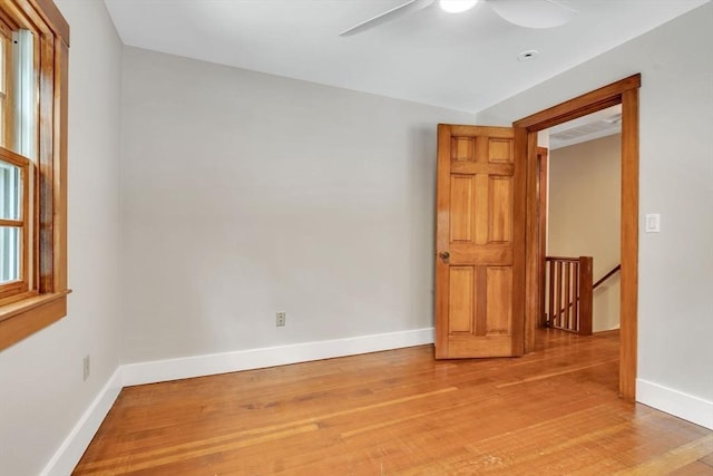 empty room with light wood finished floors, ceiling fan, and baseboards