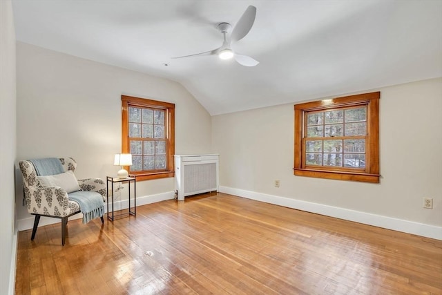 sitting room featuring lofted ceiling, a ceiling fan, hardwood / wood-style flooring, and baseboards