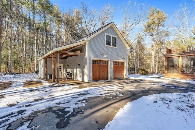 snow covered property with aphalt driveway