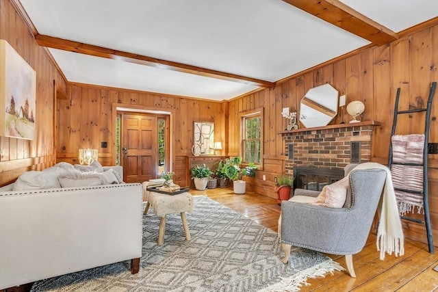 living room with light wood-type flooring, a fireplace, and beamed ceiling