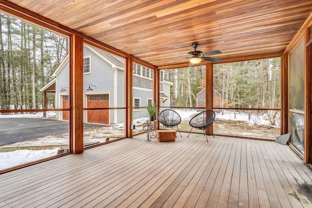 unfurnished sunroom featuring wooden ceiling and a ceiling fan