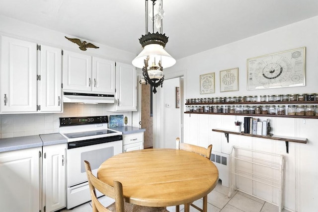 kitchen featuring electric range, white cabinetry, backsplash, light tile patterned floors, and under cabinet range hood
