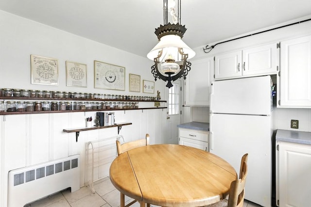 dining space with light tile patterned floors and radiator heating unit