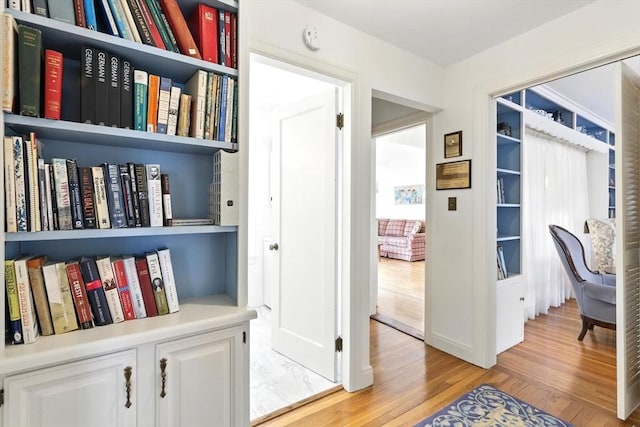 corridor featuring light wood-style floors and baseboards