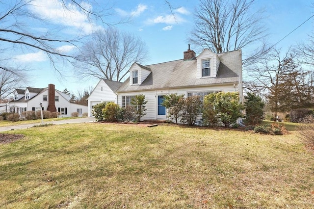 new england style home with a garage, a chimney, concrete driveway, and a front lawn