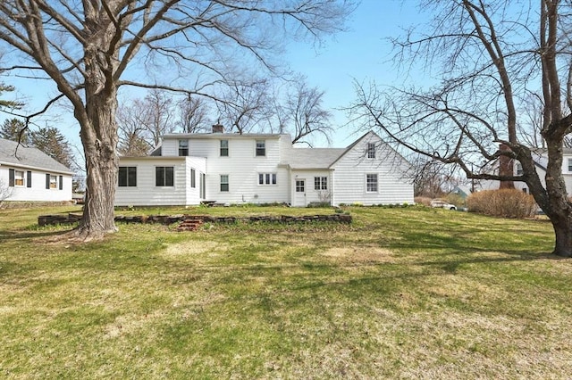 back of house featuring a yard and a chimney