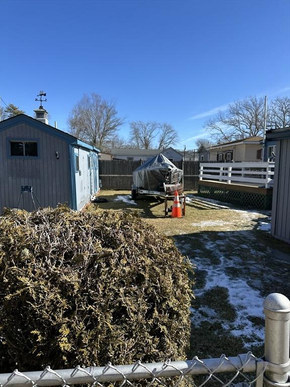 view of yard with an outdoor structure, a storage shed, and fence