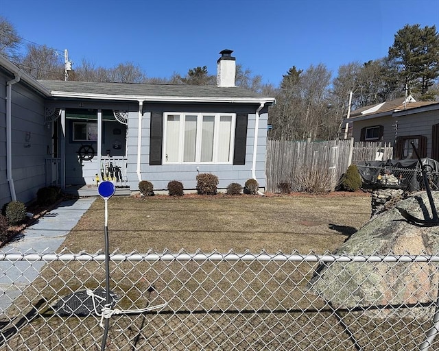 rear view of property featuring a chimney, fence, and roof with shingles