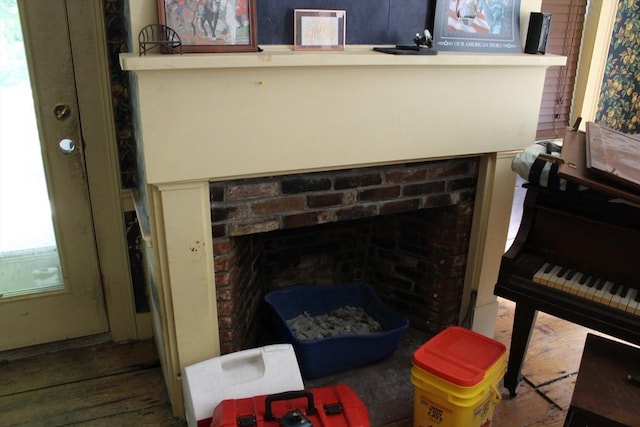interior details featuring a brick fireplace and wood finished floors