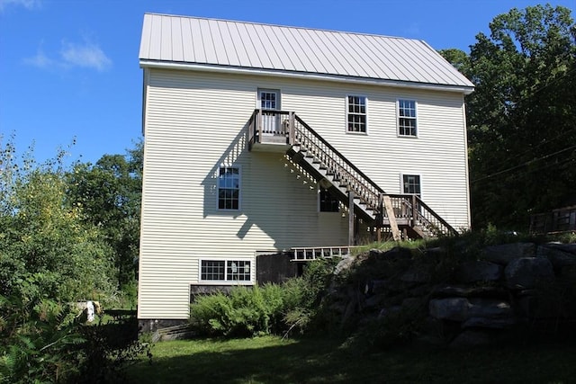 back of house featuring metal roof and stairway