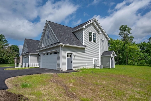 72 N Mast St Unit 1, Goffstown, NH 03045 - view of side of property featuring roof with shingles, asphalt driveway, a yard, and a shed