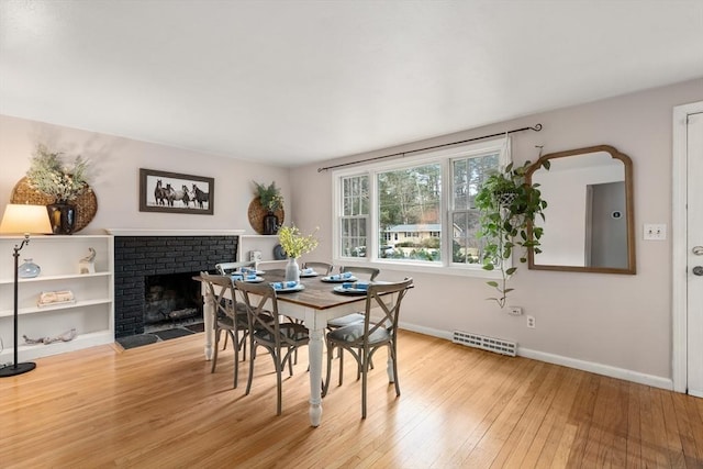 dining room with a fireplace and light hardwood / wood-style flooring