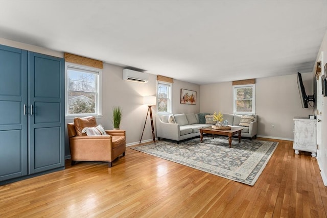 living room featuring a wall mounted air conditioner and light hardwood / wood-style flooring